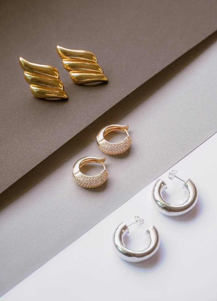 about-03 Chic assortment of gold and silver earrings on contrasting backgrounds, showcasing modern jewelry design.